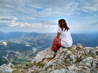 Naklejka premium a woman on top of a mountain looking at the landscape