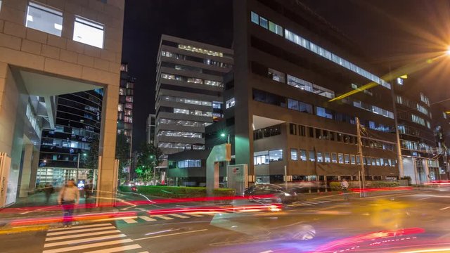 Night cityscape in business area with illuminated skyscrapers timelapse hyperlapse. San Isidro district Lima, Peru. Traffic on the street and glowing windows in offices