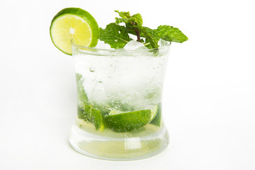 mojito cocktail lime juice with soda and water served in a glass decorated with sliced lime and mint leaves