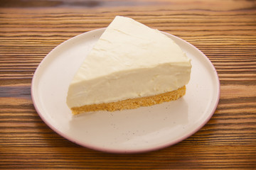 classic cheesecake on white plate on  wooden table