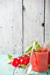 Healthy lunch fast food concept. Cold gazpacho soup. Tomato cream soup in a jar, on a summer wooden background.