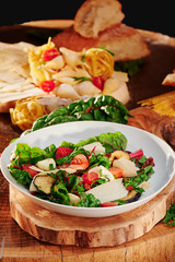 Vegetarian Salad with tomatoes, mozzarella, parmesan and fried eggplant on a wooden background. Traditional italian salad. Close-up.