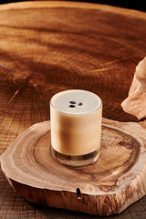 glass with coffee on a wooden background.
cappuccino decorated with coffee beans on wooden background