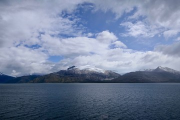 Snowy mountains in chilean fjord with blue sky and clouds, Strait of Magellan