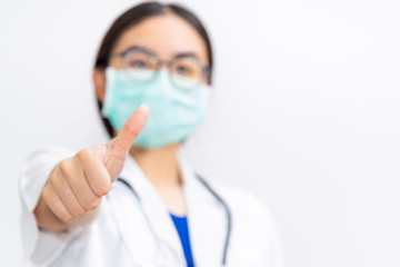 Asian young woman doctor wear mask to safety Coronavirus, Closeup physician show thumb up to support a patient in the fight against disease epidemic COVID 19 for good health concept on gray background