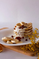 Vertical photo - pancakes in sour cream sauce with bananas and raisins
