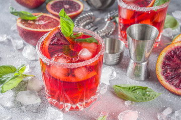 Skinny blood orange basil lemonade cocktail, with fresh bloody oranges, basil leaves and vodka,...