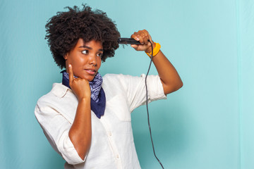 black model with curly hair wearing a neckerchief straightening her hair
