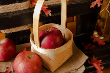
Dojrzałe czerwone jabłka na tle ozdobnego rustykalnego, małego płotka.  - obrazy, fototapety, plakaty