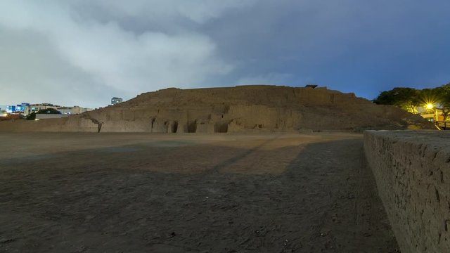 Pyramid of Huaca Pucllana day to night transition timelapse, pre Inca culture ceremonial building ruins in Lima, Peru. Clouds on a sky. Illumination is turning on