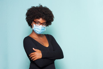 black woman with black power hair wearing protective mask wearing reading glasses