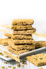Multigrain Cereal Crunchy Squares Bars with Pumpkin Seeds on Wooden Background. Selective focus.