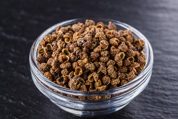 Sichuan pepper on a dark stone background