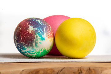 Three colored eggs similar to a ball, close-up on a white background