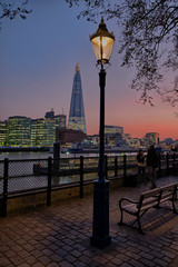 View of London city skyline on colorful sunset, with Southwark bridge over Thames river and the Shard skyscraper in the middle of the frame.