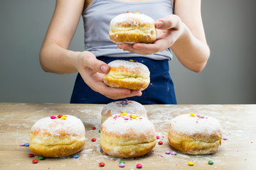 A girl holds a donuts with frosting.