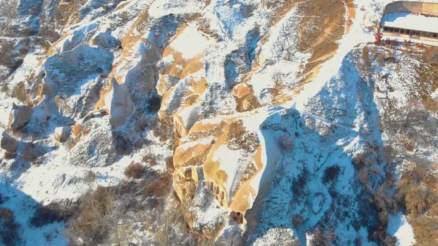 Aerial view of Pigeon Valley and cave houses covered with snow at the sunrise in Cappadocia, Turkey