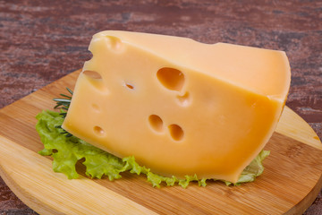 Maasdam cheese  in the board served salad leaves