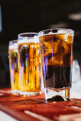 Glass of cola with ice on a bar counter
