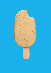 matcha popsicle with a bite on a blue background