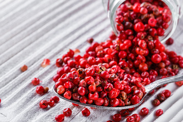 pink peppercorns on white wooden rustic background
