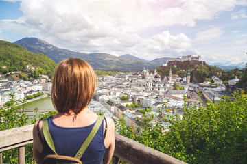 Fototapeta na wymiar Holiday in Salzburg: Young girl is enjoying the view. Historic district, Festung Hohensalzburg
