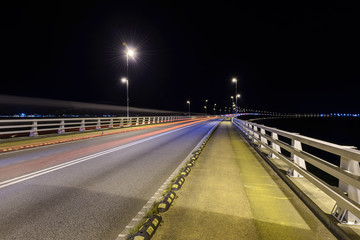 Fototapeta na wymiar light from car lights in the night at a bridge