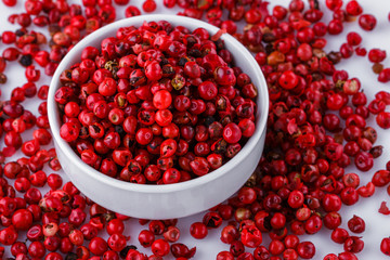 fragrant pink peppercorns on white acrylic background