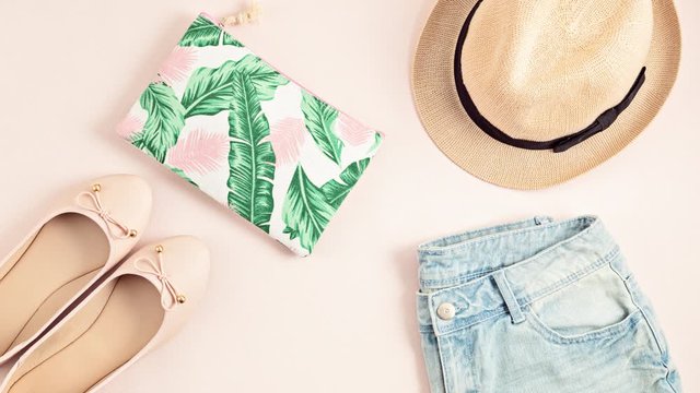 Stop motion animation. Top view over summer accessories and outfit with hat, purse, ballerina shoes, pink sunglasses. and jeans shorts. Summer style, urban outfit, vacation time, fashion blog