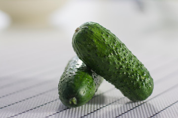 two frash cucumbers on a white table