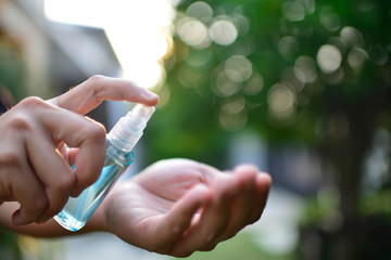 Image of a hand of a man with a bottle of alcohol washing hands.Stop and staying safe from COVID-19