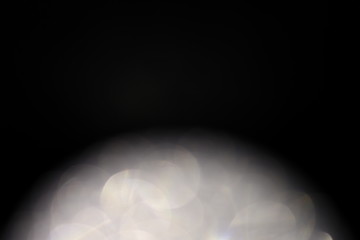 黒背景に白色の明るいボケ背景素材