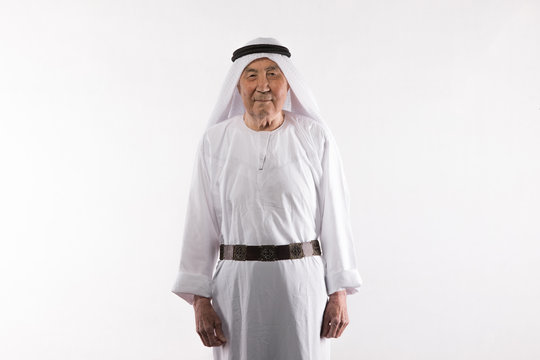 studio portrait of an old Arab man in white clothes on a white background