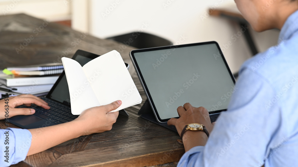Poster cropped image of business developer team working with computer laptop and tablet while sitting toget