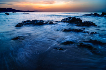 Sun, Sea and Rocky Sunrise. Impressive landscape of a beach with long exposure