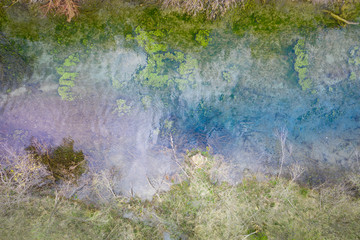 bird's eye view to river reflecting colors in swamp landscape flora
