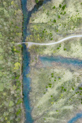 bird's eye view to river in swamp landscape with trail path crossing in austria