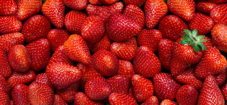 Fresa sobre monta&ntilde;a de fresas en fondo horizontal.