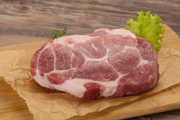 Raw pork steak over wooden board