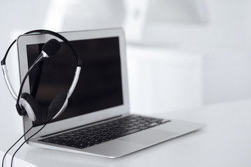 Call center and communication support, customer service help desk. VOIP headset on laptop computer
