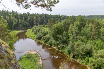 Suspension bridge over the Serga river in Deer streams national Park. Sverdlovsk region, Ural, Russia.