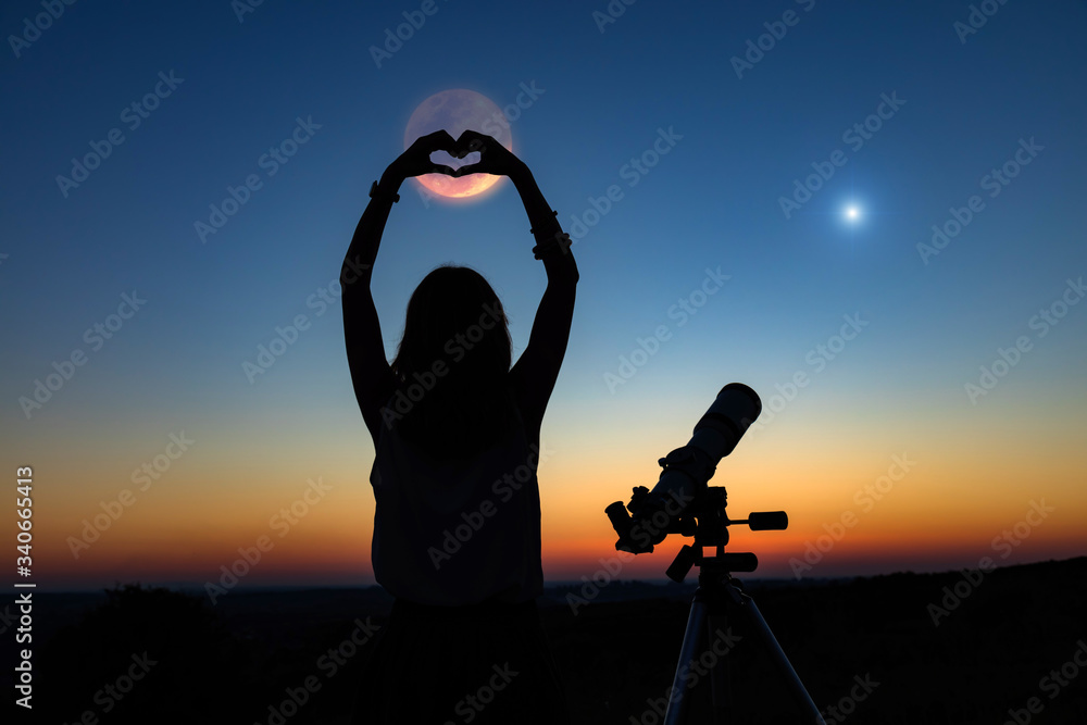 Wall mural silhouette of a woman and telescope with twilight sky.