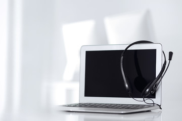 Call center and communication support, customer service help desk. VOIP headset on laptop computer