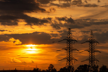 Power lines in the setting sun. A line of high-voltage wires against the sky. Sunset in the Moscow region.