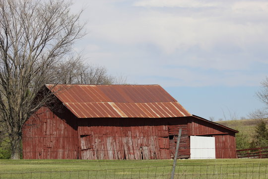 Rusted tin roof and peeling paint on a barn on older farm