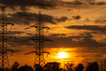 Power lines in the setting sun. A line of high-voltage wires against the sky. Sunset in the Moscow...