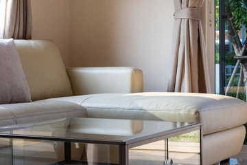 An ivory leather sofa beside the curtain in base color.