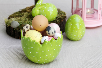 Easter table decorations with painted eggs and ceramic figurines.