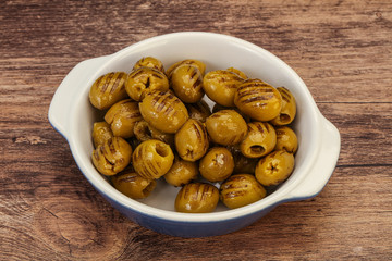 Green grilled olives in the bowl
