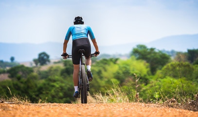 Mountain biker cycling, training and going up a steep climb.